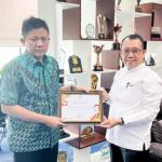 kepala Dinas Pemberdayaan Masyarakat dan Desa H Rusman, SE, MM menyerahkan sertifikat penghargaan kepada Bupati OKU Timur Ir H Lanosin ST.